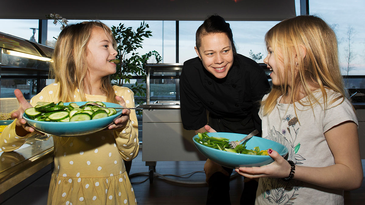 Elever diskuterar frukosten med köksmedarbetare Ellinor Lind. Foto: Jerker Andersson