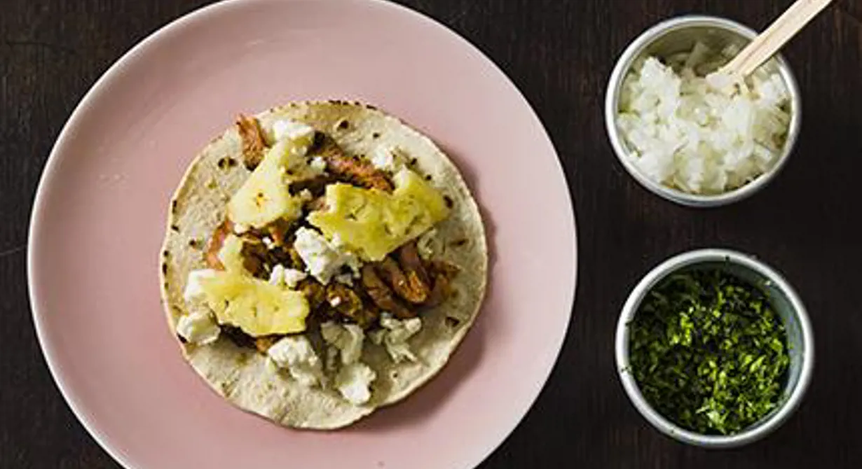 Tacos al pastor finns i vartenda gatuhörn i Mexiko och är lite av en nationalrätt. Det grillade köttet skärs tunt ner från ett kebabspett. Thomas toppar sin al pastor med ananas och smulad vitost.