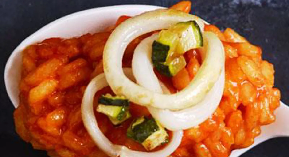 Risotton färgas röd med paprikajuice och toppas med nystekt squid och tärnad zucchini. Perfekt att servera som förrätt eller som ett snack eller amuse bouche på en sked. 