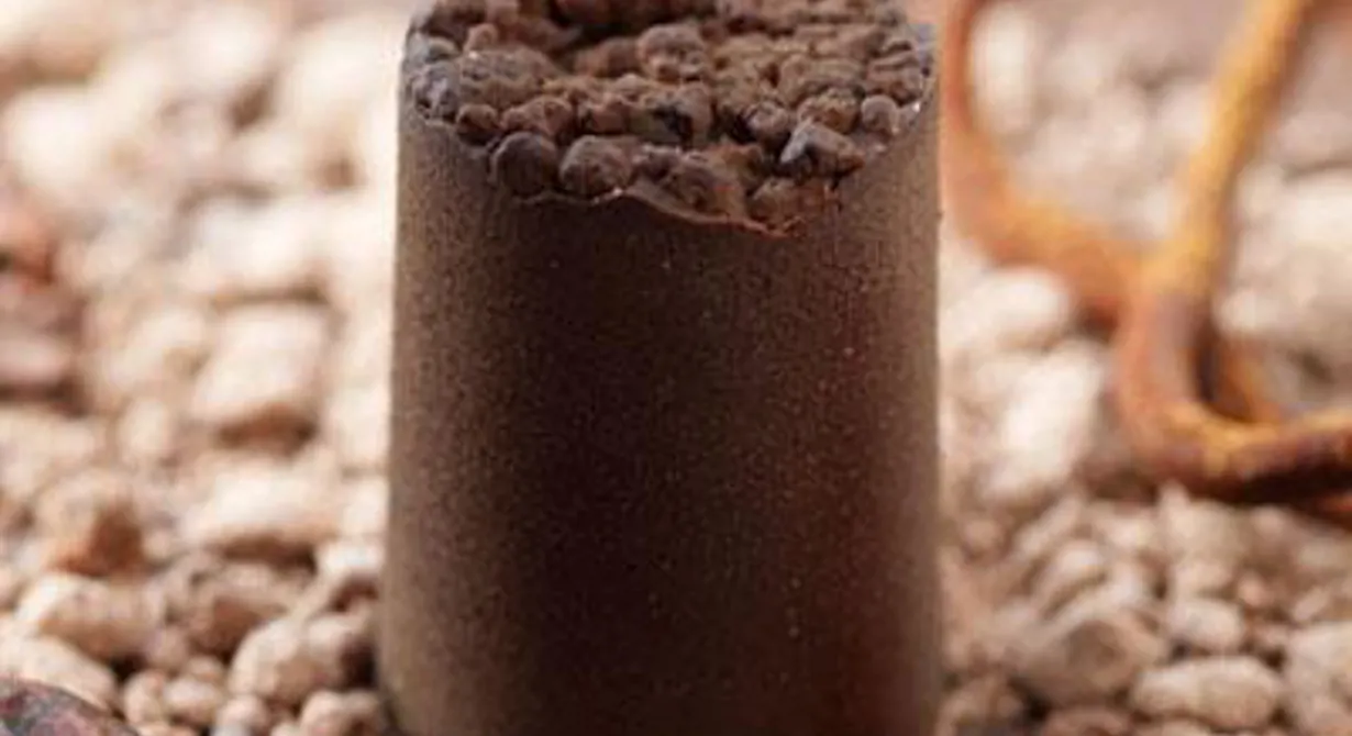I ett hölje av krispig choklad finns en inkapslad tryffel. Höljet är fryssprayat med choklad. Allt på bilden är olika texturer av choklad.