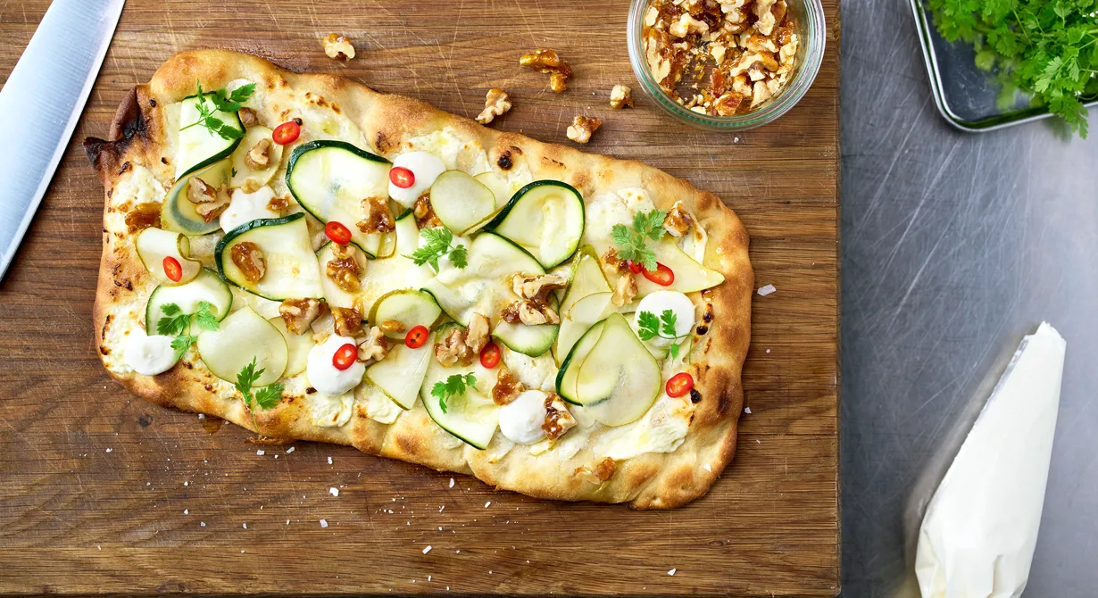 Krämig vitost är grunden på denna pinsa. Efter ugnen toppas den med tunt hyvlad och marinerad zucchini och päron, karamelliserade valnötter och crema di balsamico. Då pinsan är lättlagad och snabbakad är den perfekt att erbjuda i t ex barserveringen.