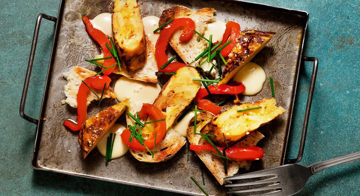 En klassisk tortilla med goda tillbehör som passar perfekt att serveras som mindre tapas eller lite större sharingrätt. Potatisen friteras mjuk och blandas med äggstanningen. Spara tid och stek tortillan på ena sidan i panna, lägg på bleck och stek klart andra sidan vid servering.
