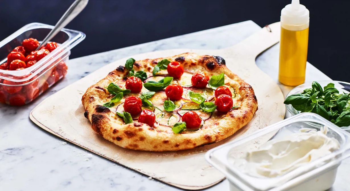 En vegetarisk pizza som passar på menyn året om. Både crème fraiche och tomatsås är basen på den här pizzan. Den toppas med tunna skivor zucchini och rödlök innan den bakas. Vid servering toppas pizzan med långbakade små smakrika tomater och späda basilikablad.