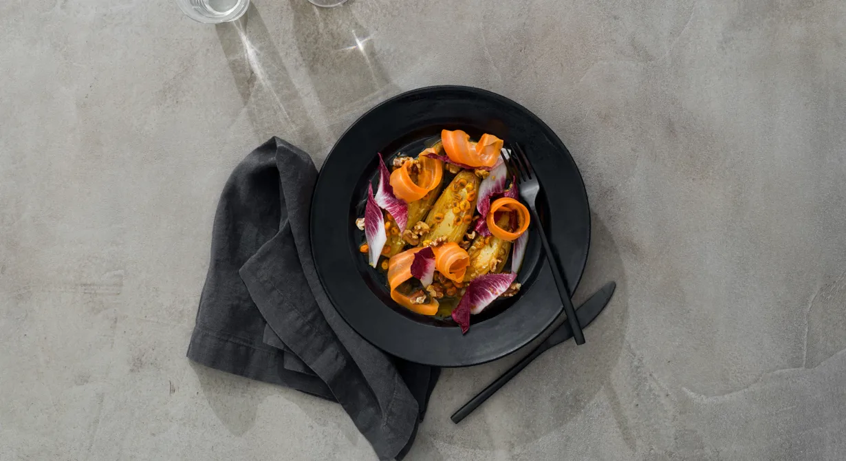 Smörstekt endive med apelsinlag smaksatt med havtorn och kittlande sanchopeppar. Dekorerad med röd endive och hyvlad morot. Pricken över i är de rostade valnötterna och valnötsdressingen som ringlas över salladen.
