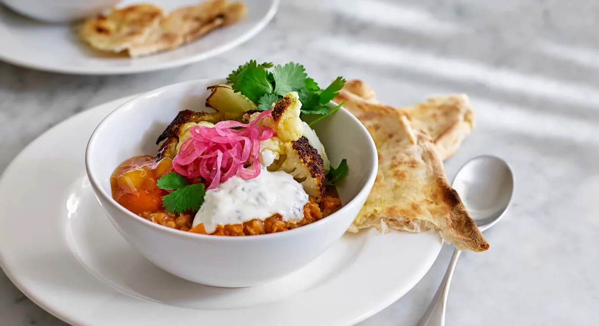 En mättande, kryddig gryta med linser och sötpotatis. Grytan blir riktigt tilltalande för gästerna då den toppas med rostad blomkål, svalkande raita och sötsyrlig picklad rödlök.