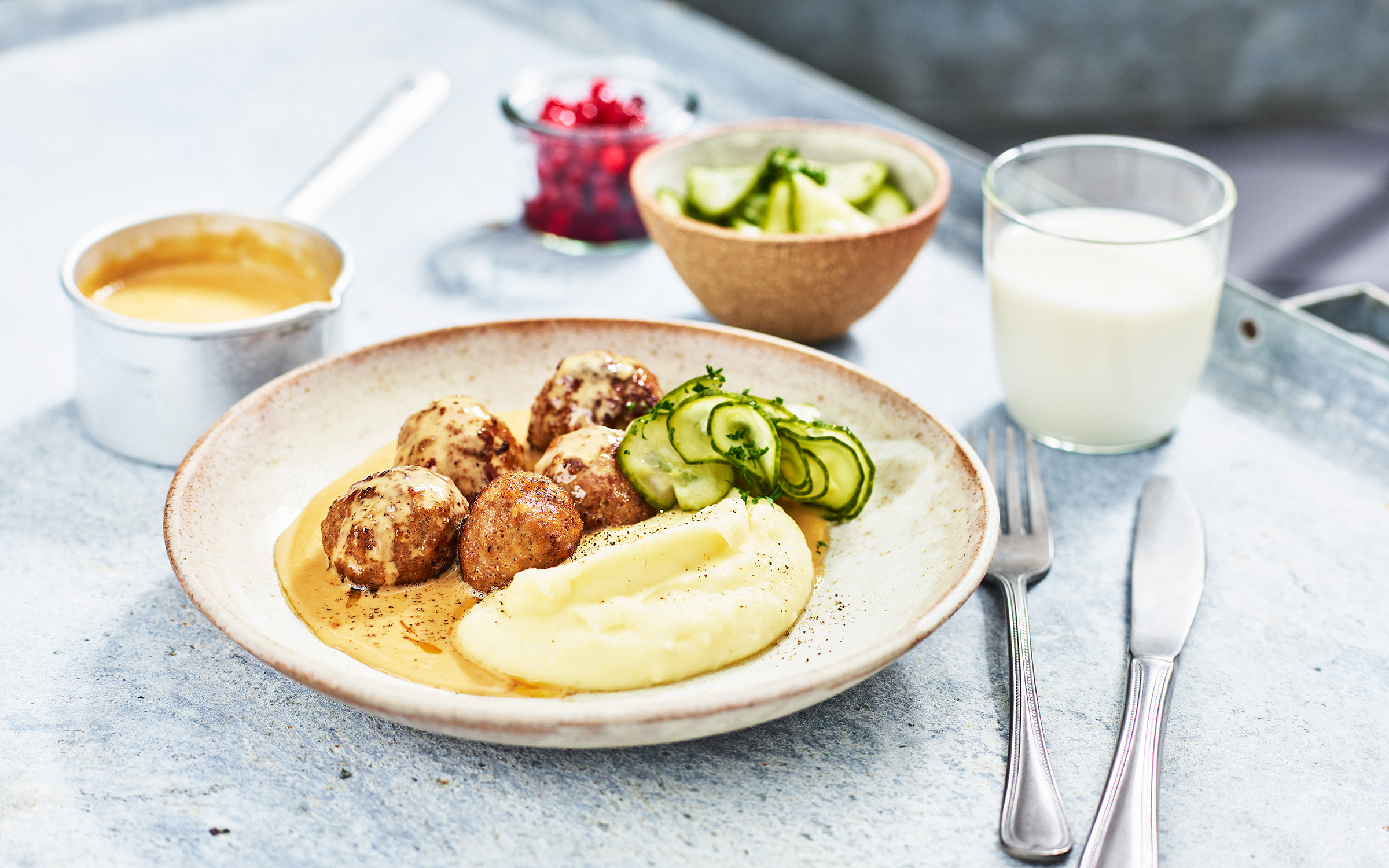Köttbullar med gräddsås, pressgurka, lingon och potatismos