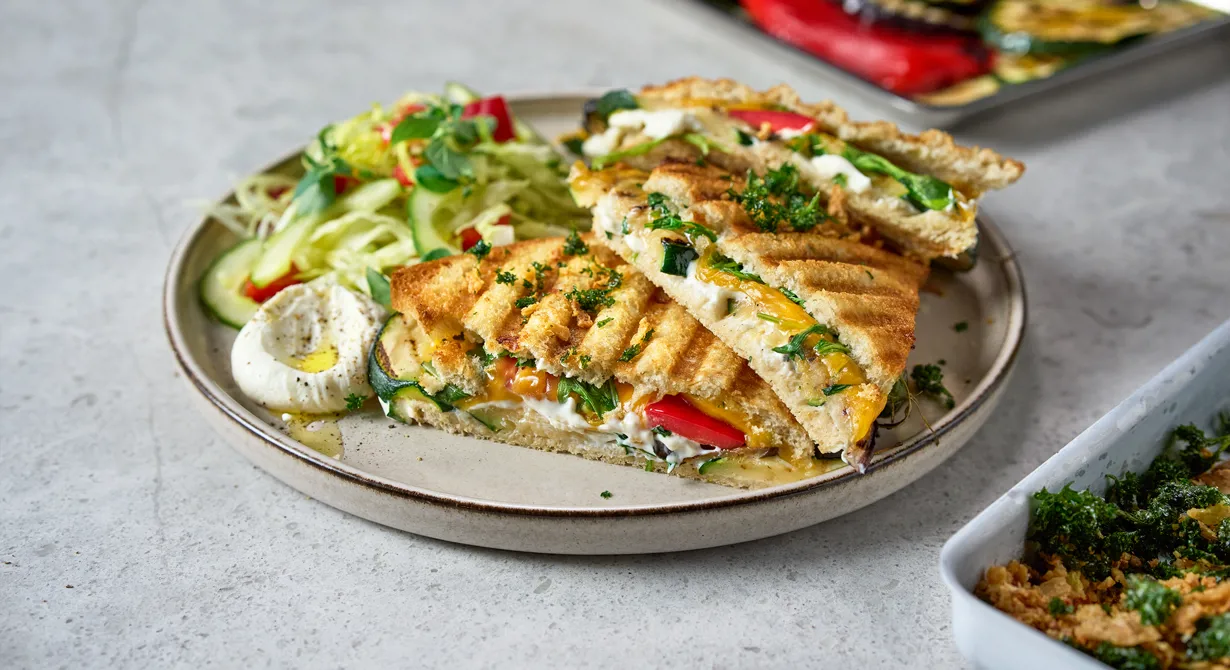 En grillad macka med krispig yta och krämigt inre är svår att motstå. Här är det krämig vitost som ger fin smak av fetaost men även cheddar, grillad paprika, zucchini och aubergine ligger mellan brödskivorna. Erbjud mackan som take away eller till sittande cafégäster.