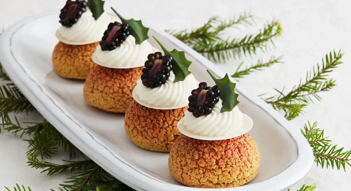 Stilrena små bakelser som imponerar i montern och håller sig länge på en söt buffé. Bakverken kallas Choux au craquelin, fyllda petit-chouer med ett frasigt täcke. Dessa är fyllda med björnbärskompott. Lätta att göra, enkla att fylla och de bjuder på en imponerande smakexplosion.