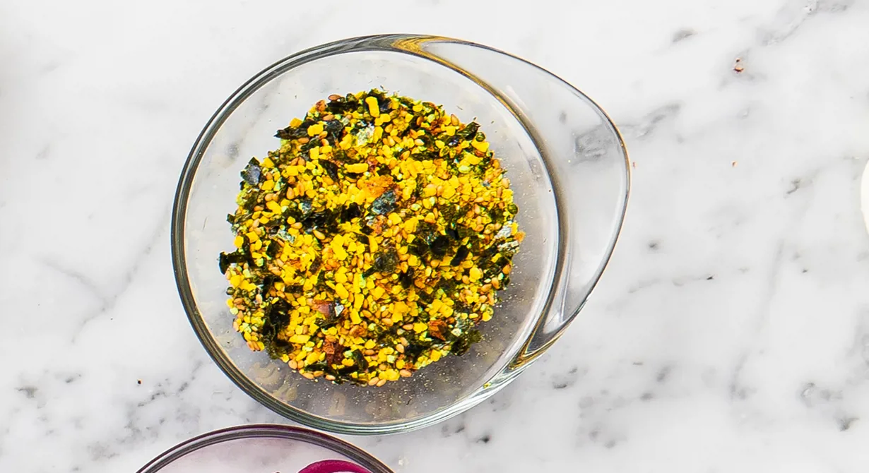 Furikake är en japansk kryddblandning bestående av svarta och vita sesamfrön, smulad nori (alg) och smulade shizoblad (påminner om vinbärsblad). Kan även innehålla t ex torkad, smulad fisk. Det här är Marie Skogströms och Hanna Normarks version.